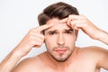 Close up photo of young man looking for acnes on his face Royalty Free Stock Photo