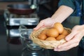 Close-up photo of the young man`s hands holding a basket full of eggs organic in the kitchen to prepare food. Royalty Free Stock Photo