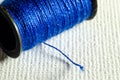 Close-up Photograph of a Bobbin of Blue Thread