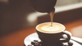 This close-up photograph captures a coffee cup filled with a frothy cappuccino sitting atop a pile Royalty Free Stock Photo