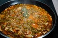 Close-up photograph of a pan cooking a rice and chicken paella in Spain during confinement