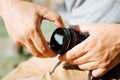 Close-up of a photographer's male hands putting a professional protective filter on the camera lens, outdoors