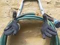 Close-up photography of an used pair of rubber and fabric gloves and a hose