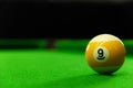 Close-up photos of billiard ball, number 9 and green floor