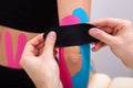 Physiotherapist Applying Kinesiology Tape On Patient`s Elbow