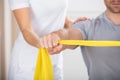 Physiotherapist Giving Man A Training With Exercise Band