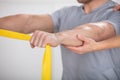 Physiotherapist Giving Man A Training With Exercise Band