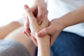 Physiotherapist pressing specific spots on female palm.