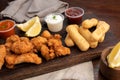 Close-up of a picada board with nuggets and tequenos with lemon slices and white and spicy sauces Royalty Free Stock Photo