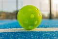 Close up of a pickleball on pickleball blue court