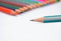 Close up picture of a blue pencil front of a line of different color wood pencils