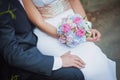 Close-up picture of bride`s and groom`s hands, holding each other and beautiful white and pink flower rose bouquet. Close-up Royalty Free Stock Photo