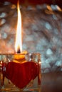 Close up Picture on the burning candle made from beeswax in the glass candle holder with red heart. Royalty Free Stock Photo