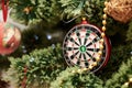 Close up picture of christmas ornaments on green artificial Xmas tree. Red and golden glass darts bauble, bead garland hanging on Royalty Free Stock Photo