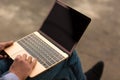 Close-up of typing man. Office worker sitting with a new laptop on the urban background. Progressive technology concept. Royalty Free Stock Photo