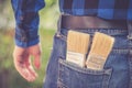 Home handyman: Rear view of a young man with paint brushes in his pocket