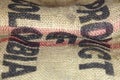 Close up picture of folded empty old burlap with big printed letters. Ecological, natural fabric, background.