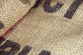 Close up picture of folded empty old burlap with big printed unrecognisible letters. Ecological, natural fabric packing issue, rus