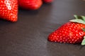 Close up picture of fresh red strawberries lying on a black stone table Royalty Free Stock Photo