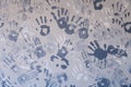 Close-up picture of a plurality of children\'s handprints painted on a gray wall. Textural background. Concept wall of memory in Royalty Free Stock Photo