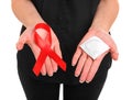 Red ribbon and a condom on female hands isolated on a white background. AIDS Awareness. Healthcare and medicine concept. Royalty Free Stock Photo