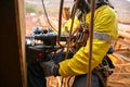 Rope access technician wearing safety harness abseiling with twin rope working at height commencing electric magnet drilling Royalty Free Stock Photo