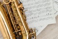 Close up picture of the saxophone laying on the note sheets