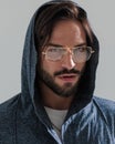 close up picture of sexy bearded man wearing hoodie and gold frame glasses Royalty Free Stock Photo