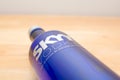 Close up picture of Skyy Vodka blue bottle on a wooden table laying down.