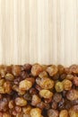 Close up picture of small raisins on a wooden background, selective focus