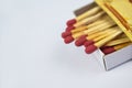 Close up picture of some flammable red fire matches gathered in a small match box