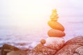 Balance, relaxation and wellness: Stone cairn outside, ocean in the blurry background. Sunshine Royalty Free Stock Photo