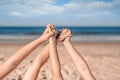 Close up picture of two little girls` hands holding together laying on the sandy ocean beach. Royalty Free Stock Photo