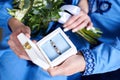 Close-up picture of wedding couple`s hands, holding white box with engagement rings and white tender flower bouquet. Wedding day Royalty Free Stock Photo