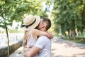 Close-up picture of young couple in love, hugging in park in summer, kissing. Pretty blond girl in stripy overall and straw hat on Royalty Free Stock Photo