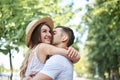 Close-up picture of young couple in love, hugging in park in summer, kissing. Pretty blond girl in stripy overall and straw hat on Royalty Free Stock Photo