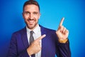 Close up picture of young handsome business man over blue isolated background smiling and looking at the camera pointing with two Royalty Free Stock Photo