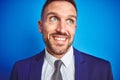 Close up picture of young handsome business man over blue isolated background smiling looking side and staring away thinking Royalty Free Stock Photo