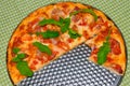 a piece of bitten pizza, decorated with arugula