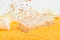 Close-up, a piece of handmade soap on scattered orange bath salts in the form of small balls Royalty Free Stock Photo