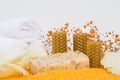 Close-up, a piece of handmade soap on scattered orange bath salts in the form of small balls, surrounded by white rose petals, Royalty Free Stock Photo