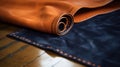 a close up of a piece of leather on a wooden floor with a blue and brown leather cover on top of the piece of leather