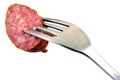 Sausage slice pitted on a fork on a white background Royalty Free Stock Photo