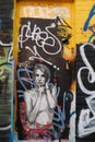 A close up of a piece of street art found on a door of a woman doing a silence sign, Shoreditch, Uk