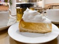 Close-up of piece transparent gelatin cake shortbread dough with meringue cream on table in cafe