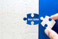 Close up piece of white jigsaw puzzle with SUCCESS text , a concept of business challenge success completion with teamwork Royalty Free Stock Photo