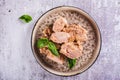 Close up of pieces of canned tuna and basil leaves on a plate top view Royalty Free Stock Photo