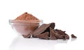 Close-up pieces of chunk black chocolate with glass bowl of cocoa powder