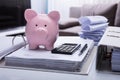 Close-up Of Piggybank And Document On White Desk