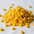 A close up of a pile of bright yellow corn kernels on a white Royalty Free Stock Photo